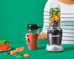 Product preview 2 of 7. Thumbnail nutribullet with cup and lid on green background.